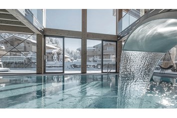 Wellnesshotel: INNs HOLZ Ausblick vom Indoorpool auf das Chaletdorf im Winter - INNs HOLZ Chaletdorf