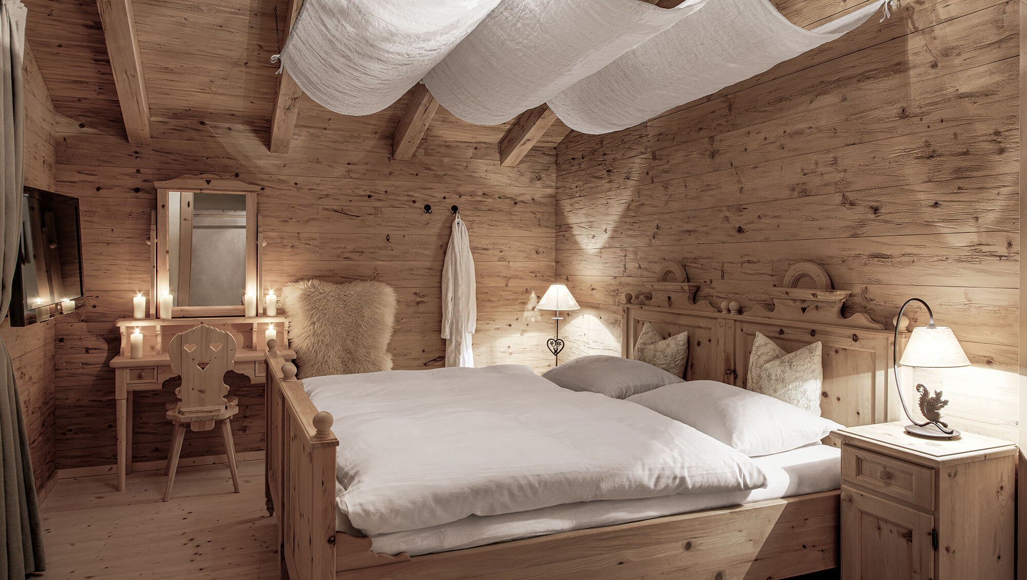 Wellnesshotel: INNs HOLZ Chalet Schlafzimmer mit Zirbenholzbett, Flatscreen TV, begehbarem Schrank samt Safe und Balkon - INNs HOLZ Chaletdorf - Zimmer | Suiten