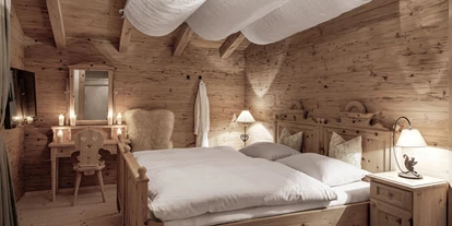 Wellnessurlaub - Private Spa - Otterbach (Sankt Florian am Inn) - INNs HOLZ Chalet Schlafzimmer mit Zirbenholzbett, Flatscreen TV, begehbarem Schrank samt Safe und Balkon - INNs HOLZ Chaletdorf