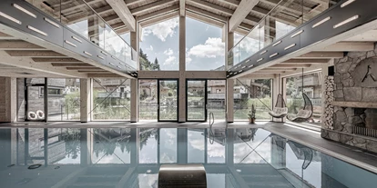 Wellnessurlaub - Private Spa - Otterbach (Sankt Florian am Inn) - INNs HOLZ Chaletdorf Indoorpool mit Kamin und Blick aufs INNs HOLZ See und Chalets - INNs HOLZ Chaletdorf
