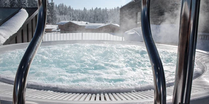 Wellnessurlaub - Private Spa - Otterbach (Sankt Florian am Inn) - INNs HOLZ Chaletdorf Wellnessbereich im angrenzenden INNs HOLZ Natur- & Vitalhotel****s Outdoorwhirlpool im Winter - INNs HOLZ Chaletdorf